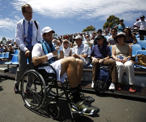 Brian Baker of the U.S. is wheeled from the court after retiring injured from his men's singles match against compatriot Sam Querrey