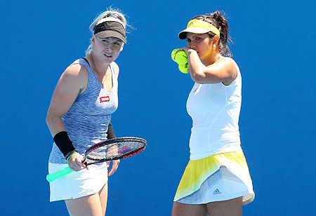 Bethanie Mattek-Sands (left) talks tactics with doubles partner Sania Mirza on Wednesday