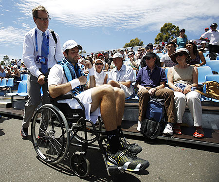 Brian Baker of the US is wheeled off the court after retiring injured from his men's singles match against compatriot Sam Querrey at the Australian Open on Wednesday