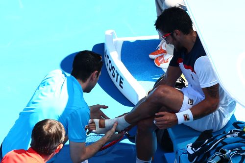 Janko Tipsarevic of Serbia receives medical attention in his fourth round match against Nicolas Almagro of Spain during day seven of the Australian Open