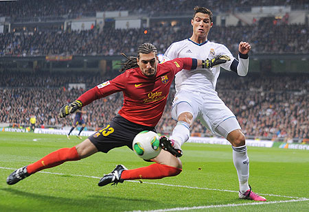 Cristiano Ronaldo (right) battles for the ball with Jose Manuel Pinto of Barcelona