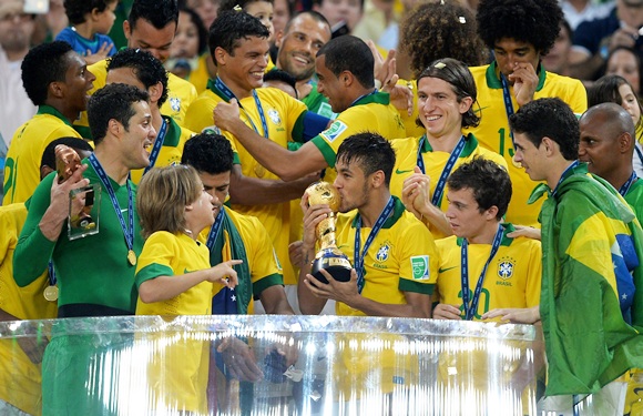 Neymar of Brazil kisses the trophy with his teammates following their victory