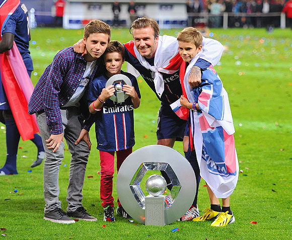David Beckham poses wih the Ligue 1 trophy and his sons Brooklyn, Romeo and Cruz