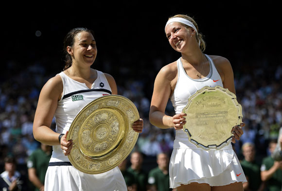 Marion Bartoli of France poses with the Venus Rosewater Dish trophy next to Sabine Lisicki of Germany and her runner-up trophy after the final