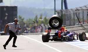 An unidentified FIA official runs over to the pits as a lost rear tyre of Red Bull Formula One driver Mark Webber of Australia bounces through the pit lane during the German F1 Grand Prix on Sunday