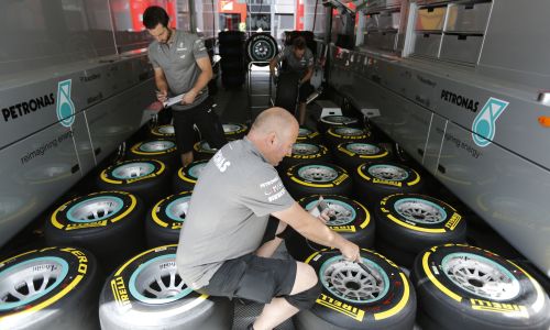 A Mercedes Formula One team technician checks the air pressure in the new Pirelli tyres