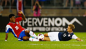 Rodney Wallace of Costa Rica (left) and Stuart Holden of the United States slide tackle as they vie for possession during the CONCACAF Gold Cup match at Rentschler Field in East Hartford, Connecticut on Tuesday