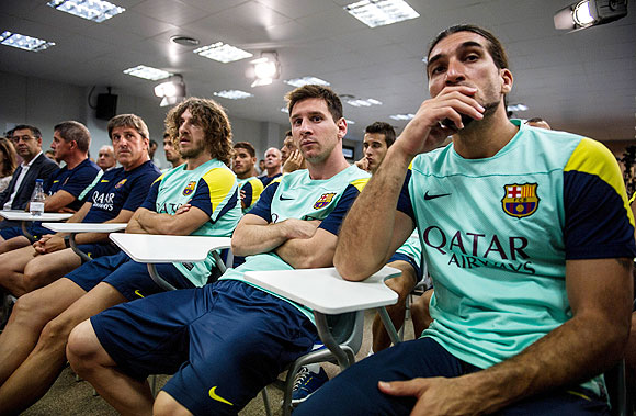 Assistant coach, Jordi Roura, Carles Puyol, Lionel Messi and Jose Manuel Pinto of FC Barcelona look on during a press conference by club President Sandro Rosell, announcing the news of Tito Vilanova's resignation at the Sant Joan Despi Sports Complex on Friday