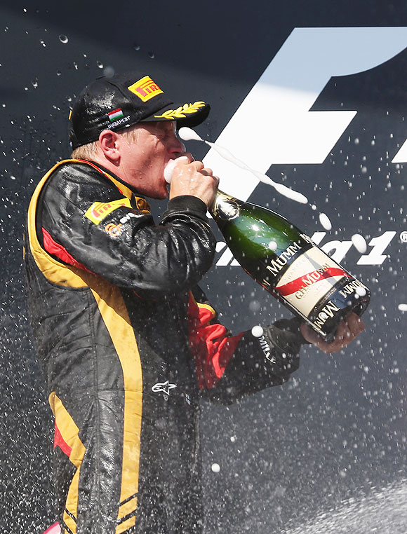 Kimi Raikkonen of Finland and Lotus celebrates on the podium after finishing second during the Hungarian Formula One Grand Prix at Hungaroring in Budapest, Hungary, on Sunday