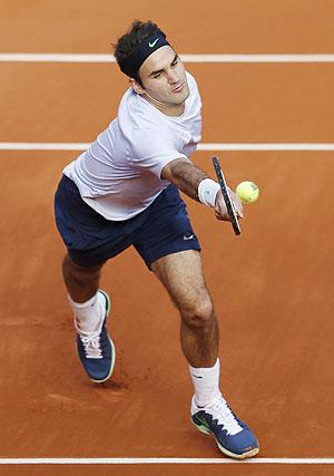 Roger Federer hits a return against Gilles Simon during the French Open at Roland Garros on Sunday