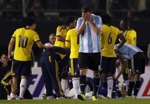Argentina's Gonzalo Higuain (C) covers his face after being expelled by referee Marlon Escalante (not seen) of Venezuela during their 2014 World Cup qualifying soccer match against Colombia in Buenos Aires