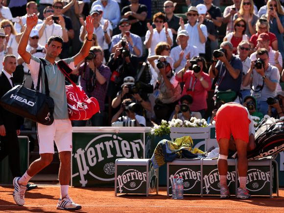 Novak Djokovic of Serbia applauds the fans as he walks off court after defeat in his men's singles semi-final match against Rafael Nadal