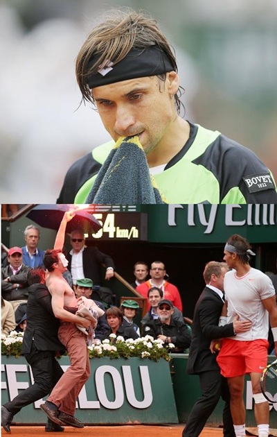 David Ferrer (above) Rafael Nadal of Spain looks on as security guards restrain a protester after he lit a flare and ran on   court