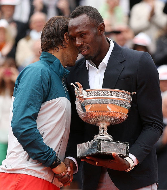 Rafael Nadal of Spain is presented with the Coupe des Mousquetaires trophy by Usian Bolt after the men's singles final against David Ferrer on Sunday