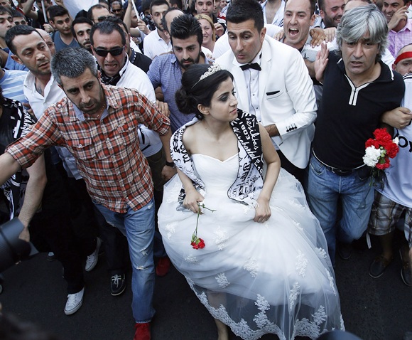 A newlywed couple joins protesters as they march towards Taksim Square in Istanbul