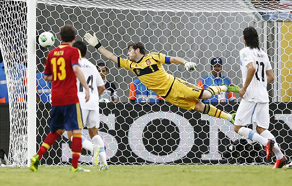 Spain's goalkeeper Iker Casillas (centre) dives full stretch but fails to make a save off a free kick goal by Uruguay's Luis Suarez during their Confederations Cup Group B match at the Arena Pernambuco in Recife, Brazil on Sunday