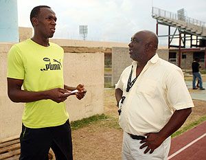 Coach Glenn Mills talks to Usain Bolt
