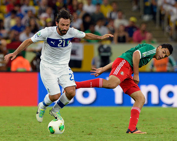 Andrea Pirlo dribbles the ball past Raul Jimenez of Mexico