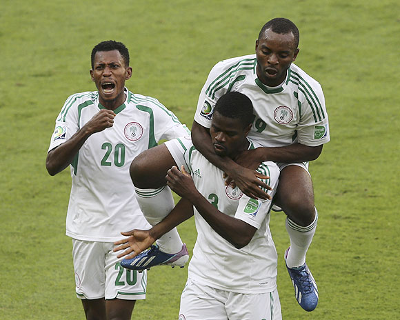Nigeria's Sunday Mba (top) celebrates with teammate Uwa Echiejile, who scored the team's first goal, against Tahiti during their Confederations Cup match at the Estadio Mineirao in Belo Horizonte on Monday
