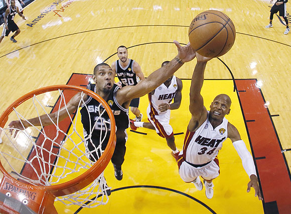San Antonio Spurs power forward Tim Duncan (21) and Miami Heat shooting guard Ray Allen (34) reach for a rebound