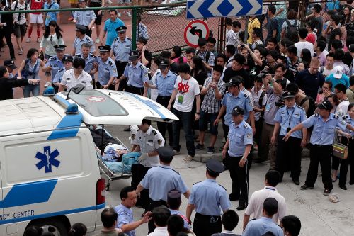 An injured person is carried to an ambulance after a stampede during David Beckham's visit at Tongji University