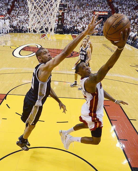 Miami Heat point guard Mario Chalmers (15) scores on a play past San Antonio Spurs power forward Tim Duncan (21) during Game 7 of their NBA Finals on Thursday