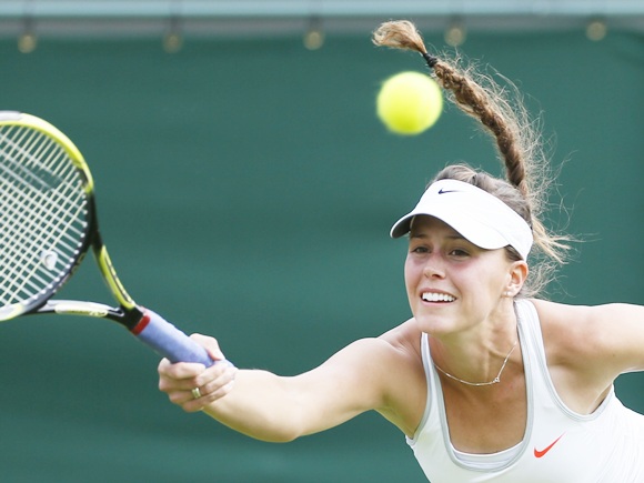 Michelle Larcher De Brito of Portugal hits a return to Maria Sharapova
