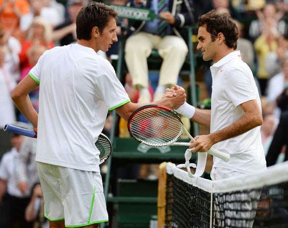 Sergiy Stakhovsky of Ukraine shakes hands at the net with Roger Federer of Switzerland after their match