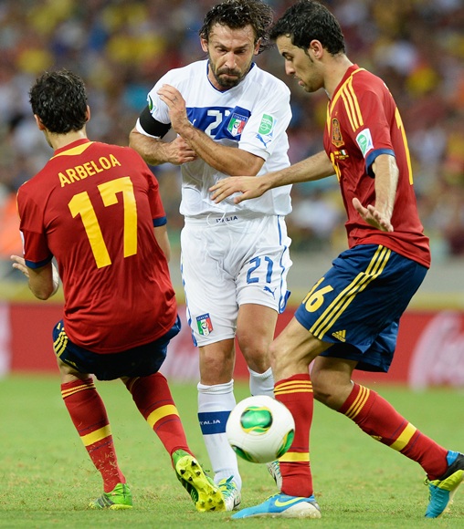  Andrea Pirlo of Italy is challenged by Alvaro Arbeloa of Spain and Sergio Busquets (right)