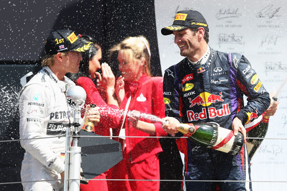 Race winner Nico Rosberg (L) of Germany and Mercedes GP celebrates on the podium with second placed Mark Webber at Silverstone Circuit