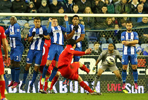 Liverpool's Luis Suarez scores the third goal from a free kick during their match against Wigan Athletic on Saturday