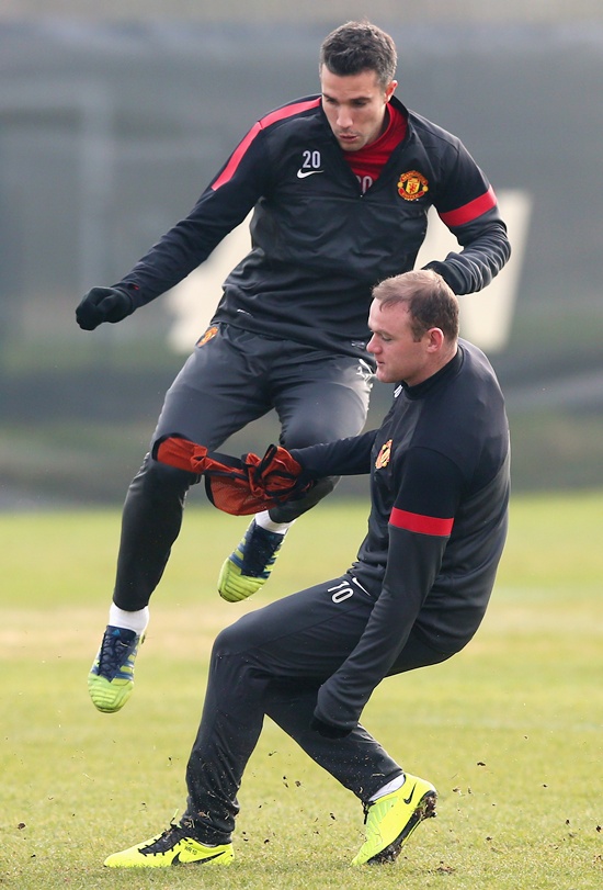 Wayne Rooney of Manchester United tackles Robin Van Persie