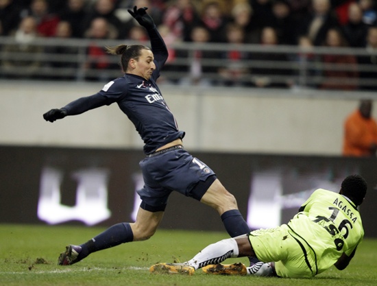 Kossi Agassa (right) of Stade Reims fights for the ball with Zlatan Ibrahimovic of Paris St Germain