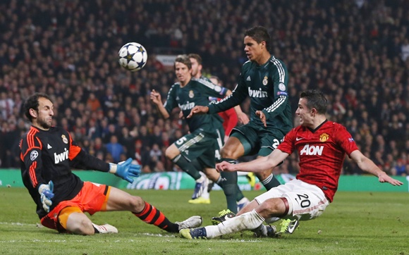 Manchester United's Robin van Persie (right) tries a shot against Real Madrid's goalkeeper Diego Lopez (left)