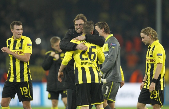 Borussia Dortmund's coach Juergen Klopp hugs his players