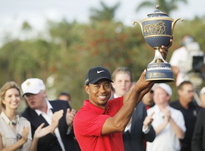 Tiger Woods hoists the Gene Sarazen Trophy