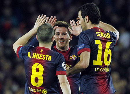 Barcelona's Lionel Messi (centre) celebrates victory over AC Milan with teammates Andres Iniesta (left) and Sergio Busquets
