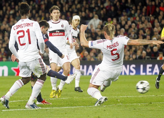 Barcelona's Lionel Messi (second left) scores his second goal past AC Milan's Philippe Mexes (right)