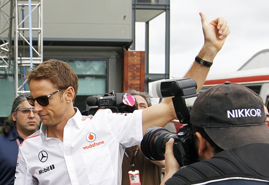 McLaren Formula One driver Jenson Button of Britain waves to fans