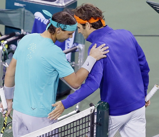 Rafael Nadal (left) of Spain and Roger Federer of Switzerland pat each other
