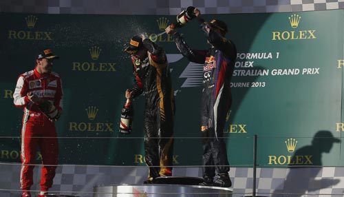 Red Bull Formula One driver Sebastian Vettel of Germany sprays champagne on Lotus Formula One driver Kimi Raikkonen of Finland (C), as Ferrari Formula One driver Fernando Alonso of Spain (2nd L) looks on after the Australian F1 Grand Prix