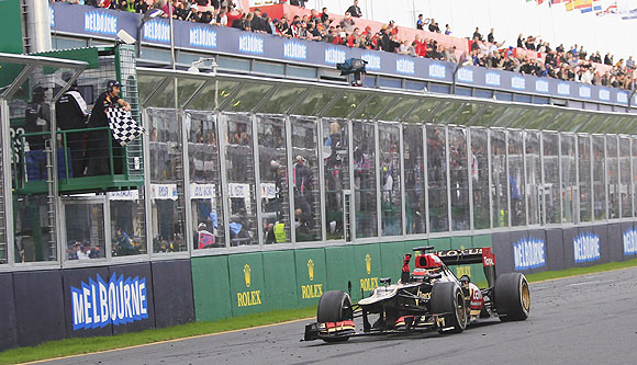 Lotus Formula One driver Kimi Raikkonen takes the chequered flag as he wins the Australian F1 Grand Prix at the Albert Park circuit in Melbourne Mon Sunday