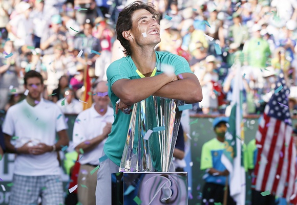 Rafael Nadal of Spain smiles as he leans on his trophy