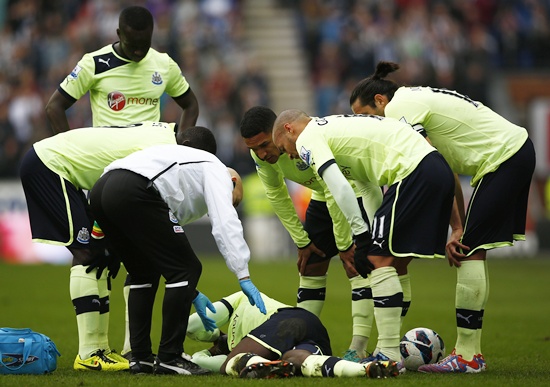 Newcastle United players look at their injured teammate Massadio Haidara
