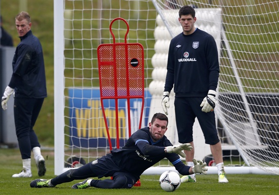 England's Ben Foster makes a save during a training session