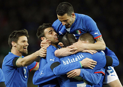 Italy players celebrate with Mario Balotelli (centre) after scoring the equaliser during their international friendly against Brazil at the Stade de Geneve in Geneva on Thursday