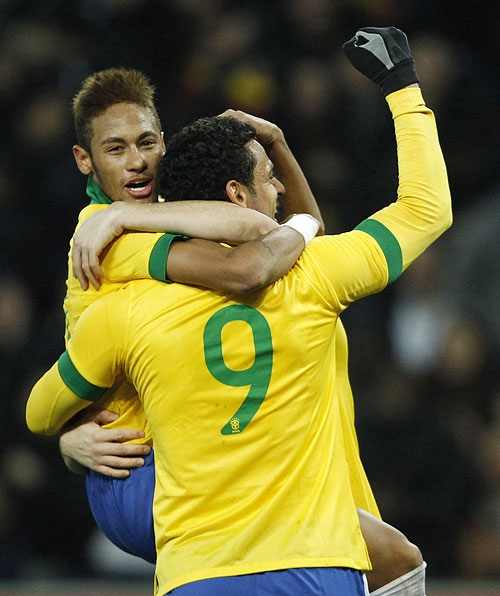 Brazil's Neymar (left) celebrates with teammates Fred and Oscar (hidden) after the latter scored the second goal during their international friendly against Italy at the Stade de Geneve in Geneva on Thursday