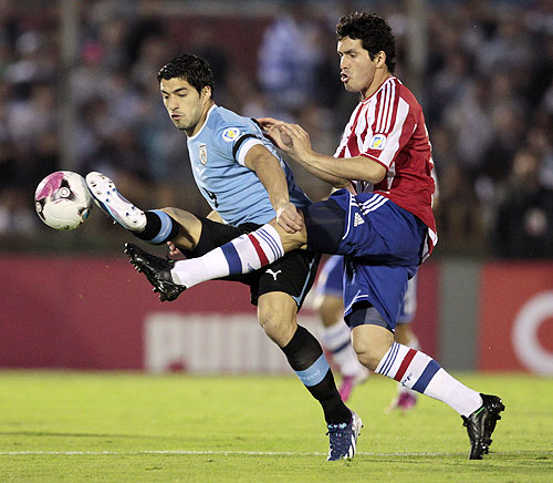 Paraguay's Cristian Riveros (right) and Uruguay's Luis Suarez vie for possession during their 2014 World Cup qualifying match in Montevideo on Friday