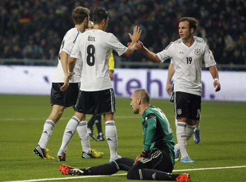 Germany's national soccer team players celebrate a goal next to Kazakhstan's goalkeeper Andrei Sidelnikov