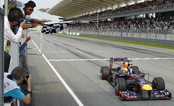 Red Bull driver Sebastian Vettel of Germany takes the chequered flag